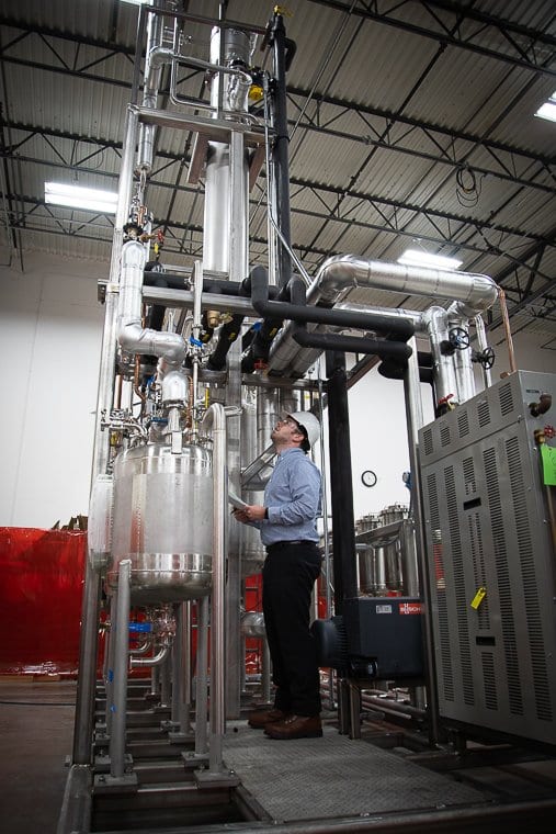 A member of the EPIC QA team inspects distillation equipment ready for shipment
