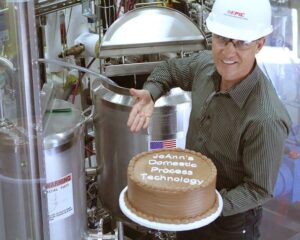 EPIC CEO John Schott displays a cake in front of a batch mixing system