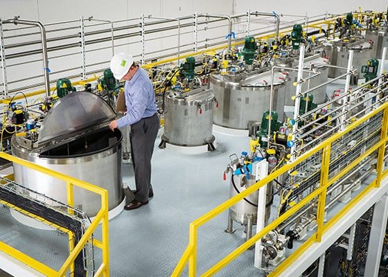An engineer inspects a batch-mixing system